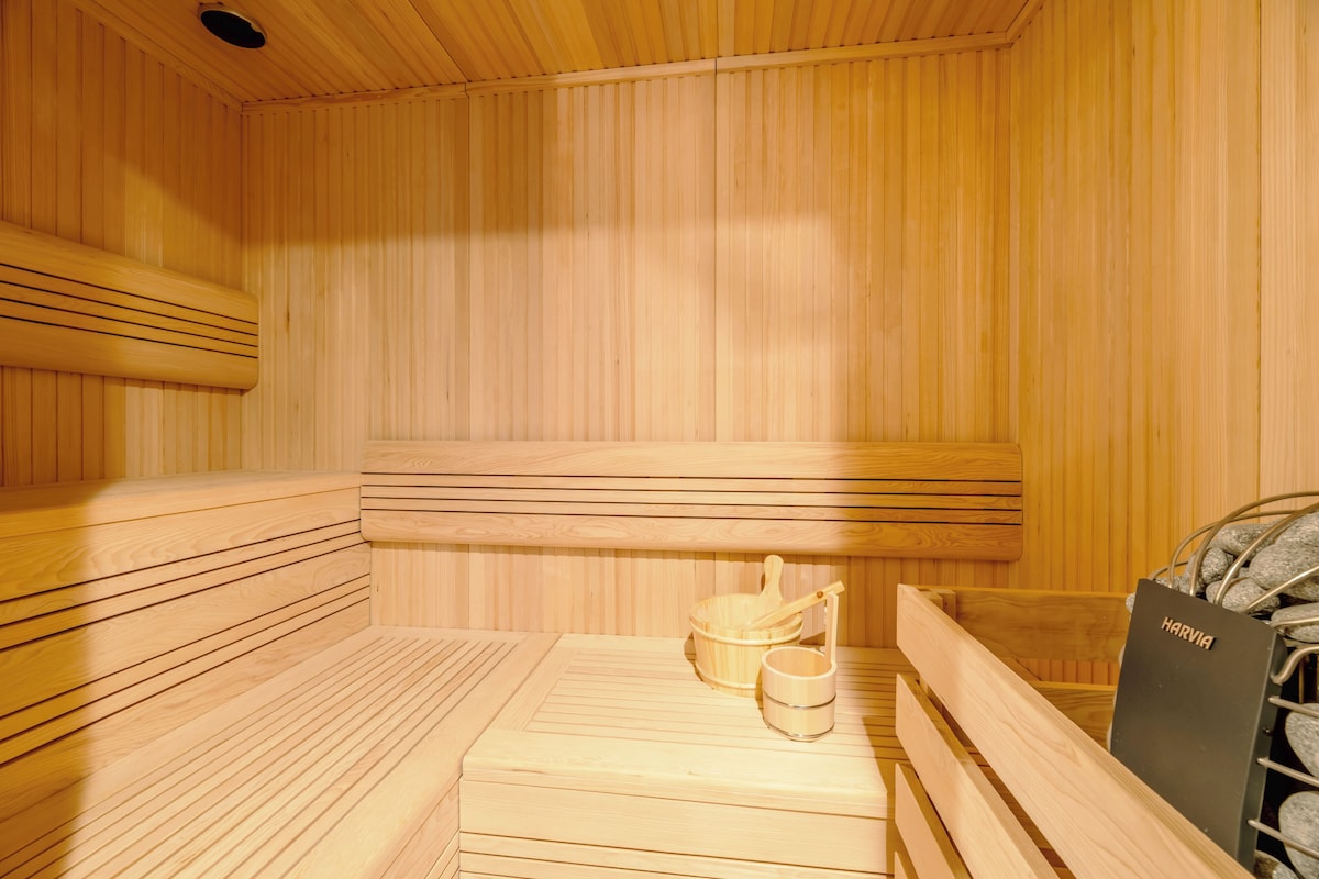 Ein Saunaraum mit Holzbänken und einem Holz-Eimer.