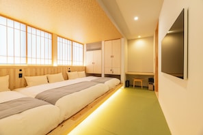 Ein modernes Schlafzimmer mit einem großen Bett, einem Holzkopfstück und einem Schreibtischbereich.