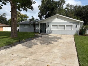 A residential house with a garage, a driveway, and a well-maintained lawn.