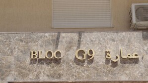 A building entrance with a marble facade and a dark wooden door.