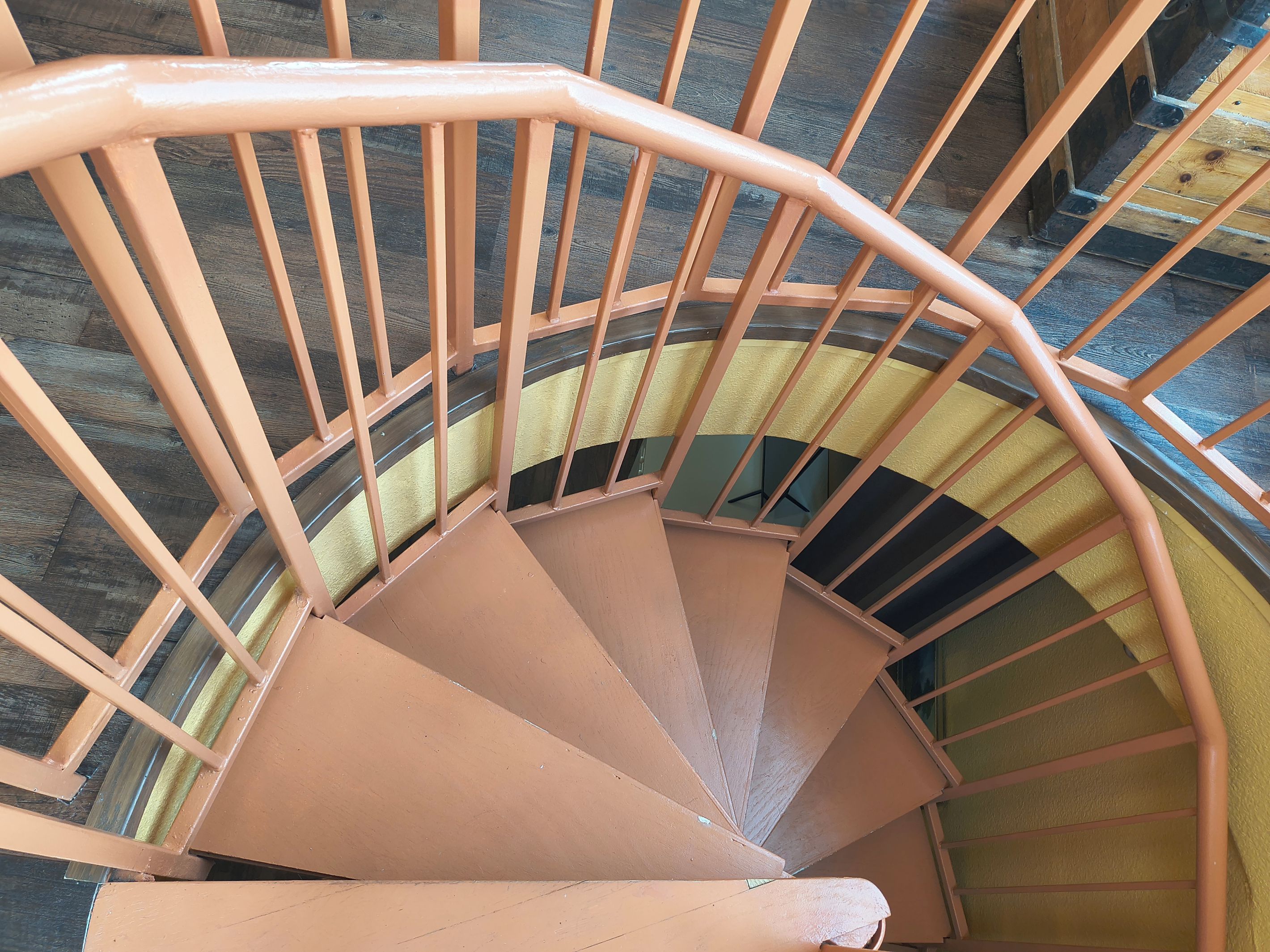 A spiral staircase with a handrail and steps.