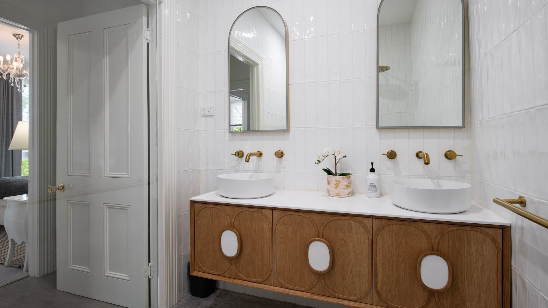 A bathroom with two sinks, a mirror, and a wooden vanity.
