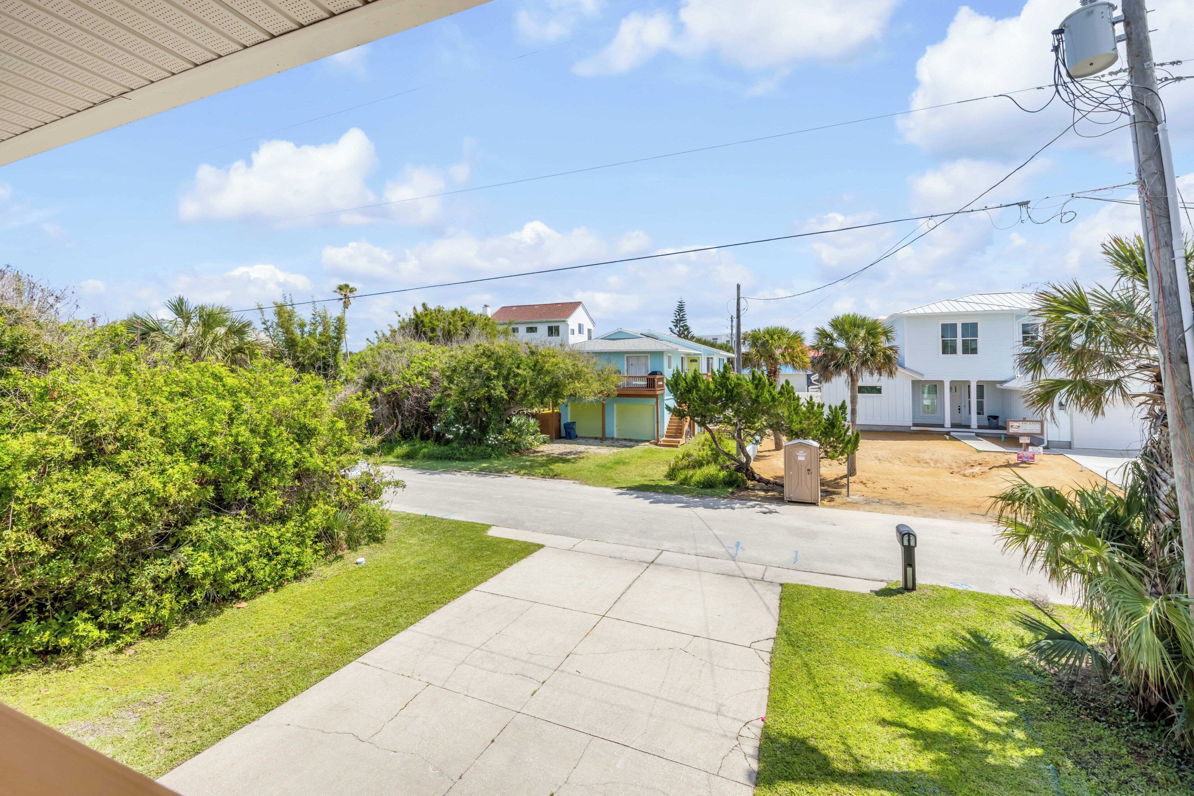 A residential area with houses, a clear sky, and a sidewalk.