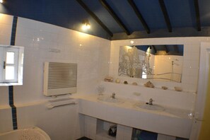 Un baño con dos lavamanos, un espejo y una ducha.