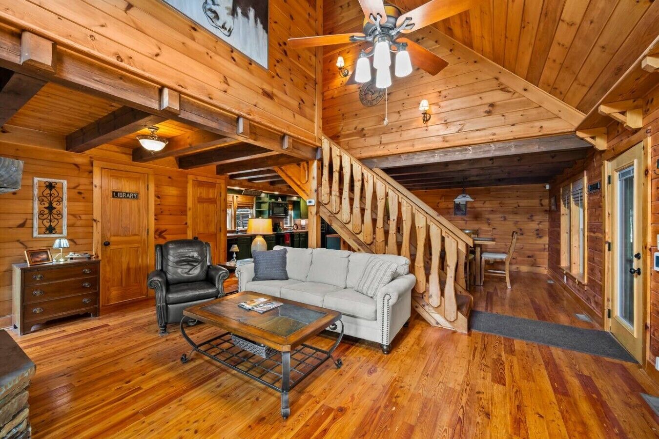 L’intérieur d’une cabane en bois comprend un salon, un escalier et un coin cuisine.