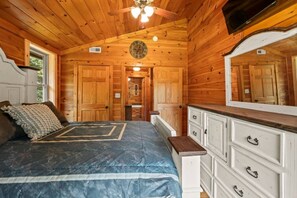 A wooden cabin bedroom with a bed, dresser, and a ceiling fan. - The Equestrian Hideaway (8-minutes from TIEC)! (Rutherfordton)
