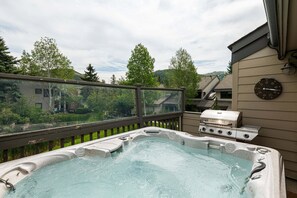 A hot tub on a deck with a view of a residential area and hills. - Spacious 4BR Deer Valley condo with 3.5 baths, ideal for 12 guests. (Park City)