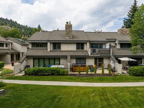 A two-story residential building with a covered patio area, a hot tub, and a landscaped front yard. - Spacious 4BR Deer Valley condo with 3.5 baths, ideal for 12 guests. (Park City)