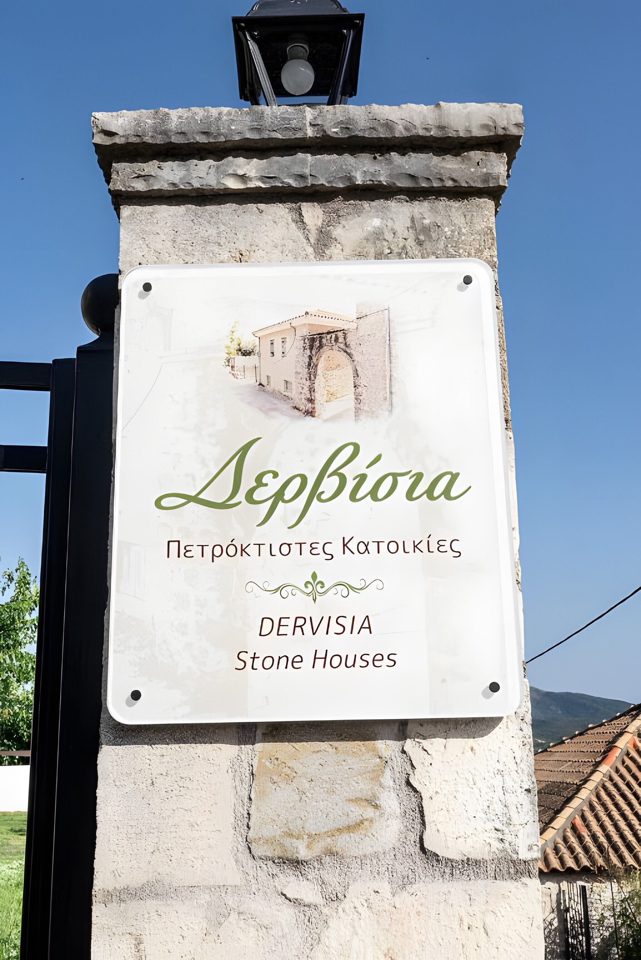 Schild für 'Dervisia Stone Houses' mit Illustration einer Steinscheune.