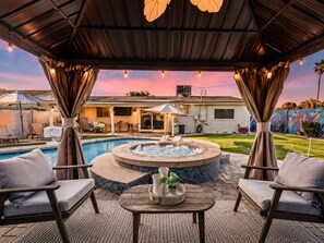An outdoor patio with a hot tub, seating, and a view of a house. - Old Town 5 Min, Heated Pool & Spa & Putting Green (Scottsdale)