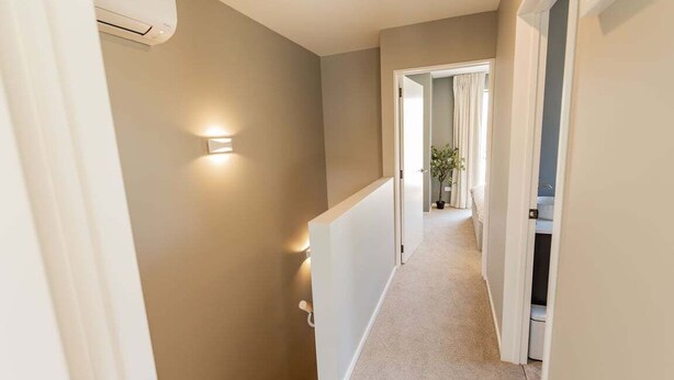 Passadís estret amb terra endollida, unes escales i una porta que dona a una altra habitació.
