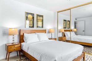 Ein Hotelzimmer mit einem großen Bett, zwei Nachttischen und einem Spiegel.