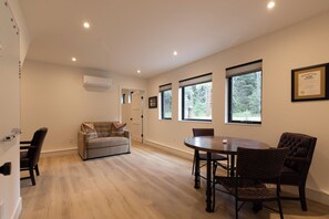 A room with a dining table, chairs, a sofa, and a framed certificate on the wall. - Pond-View Guest House | River Access, 2 Kings (Durango)
