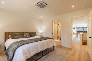 A bedroom with a bed, bedside lamp, and a walk-in closet.