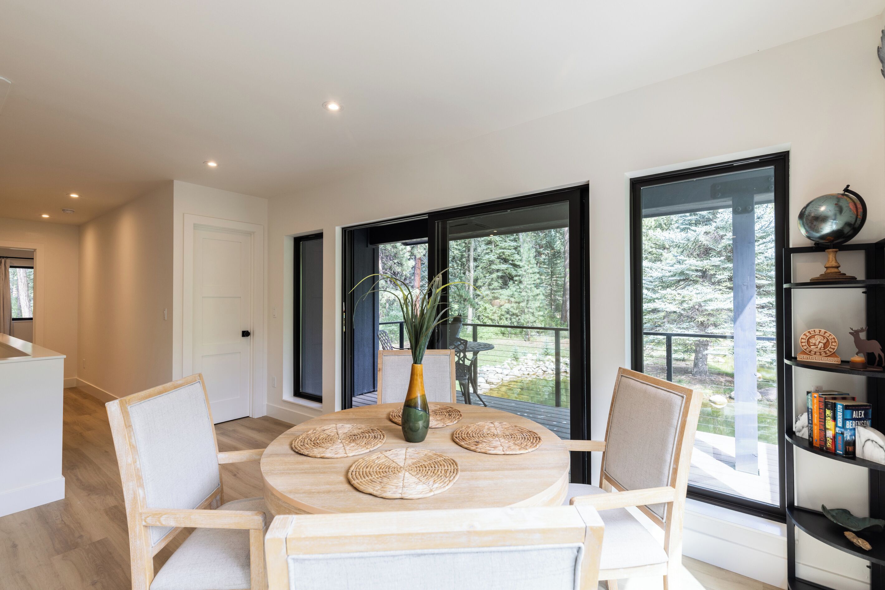 Un espace repas moderne avec une table ronde, des chaises et un vase rempli de plantes.