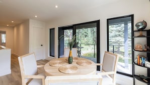 Un espace repas moderne avec une table ronde, des chaises et un vase rempli de plantes.