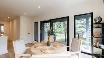 Un espace repas moderne avec une table ronde, des chaises et un vase rempli de plantes.