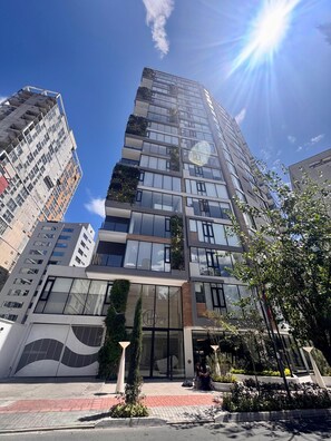 A modern building with multiple floors, large windows, and a glass facade. - Vrbo Property (Quito)