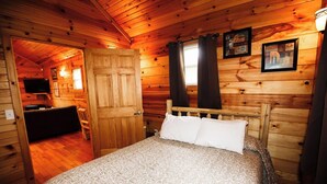 Een houten kamer met een bed, een bureau en een televisie.