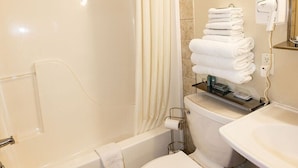 Een badkamer met een bad, toilet en wastafel.
