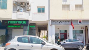 A building with multiple storefronts, including a pharmacy and a bank.