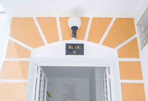 A building entrance with a sign labeled 'BLOC B' and a light fixture above it.