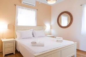 Ein Hotelzimmer mit Bett, Nachttischen, einem Spiegel und einer Klimaanlage.