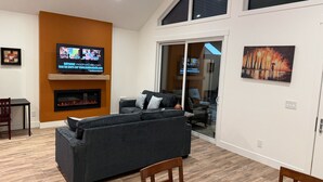 A modern living room with a fireplace, a television, and a large window.