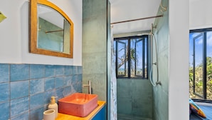 A bathroom with a wooden vanity, a red basin, a mirror, and a shower with a view of the outdoors. - The Headlands Chalets - Cabin 2 (Point Lookout)