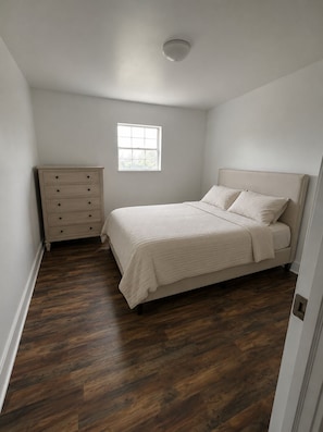 A bedroom with a bed, a dresser, a window, and a ceiling light. - Stylish Nashville Getaway Near Downtown – Comfort, Convenience & Southern Charm! (Nashville)
