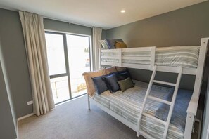 A bunk bed with pillows and a window with curtains. - Prime Location | Modern Comfort | Pools - HS7652 (Hanmer Springs)