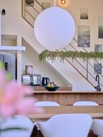 Cocina moderna con horno integrado, cafetera y frutero sobre la encimera.
