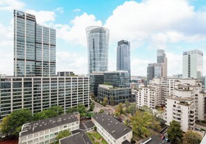 Een stadsgezicht met moderne hoge gebouwen, waaronder een opvallende toren met een gebogen glazen façade.