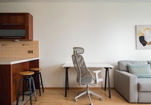 Un espace de vie moderne comprenant un coin cuisine, une table à manger et un canapé.