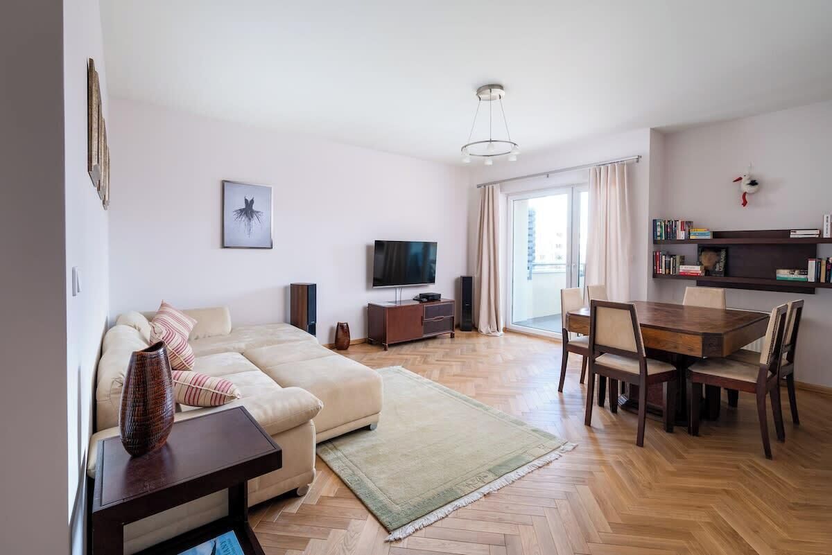 A living room with a sofa, TV, and dining area.