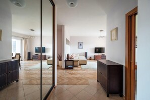 A modern hotel room with a large mirror, a bed, a TV, and a desk. - Wyględowska 2-Bedroom Apartment (Warszawa)