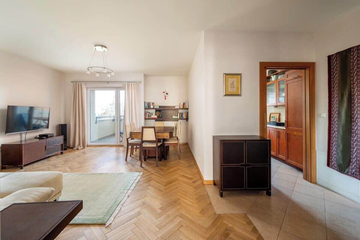 Una sala de estar moderna con televisión, sofá y comedor.