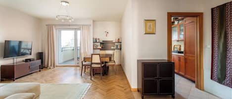 Una sala de estar moderna con televisión, sofá y comedor.
