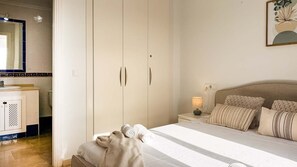 A bedroom with a bed, nightstand, lamp, and a wardrobe. - Pink La Perla Apartment (Zenia, La)