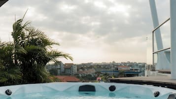 Un jacuzzi con vista despejada del entorno, incluyendo edificios y palmeras.