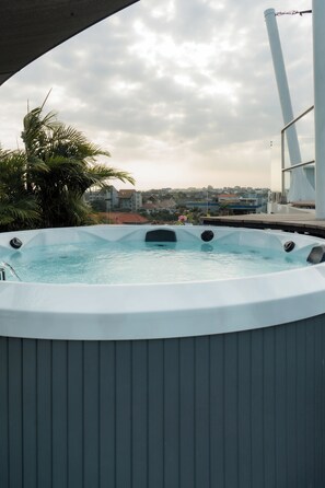 Un jacuzzi con vista despejada del entorno, incluyendo edificios y palmeras.