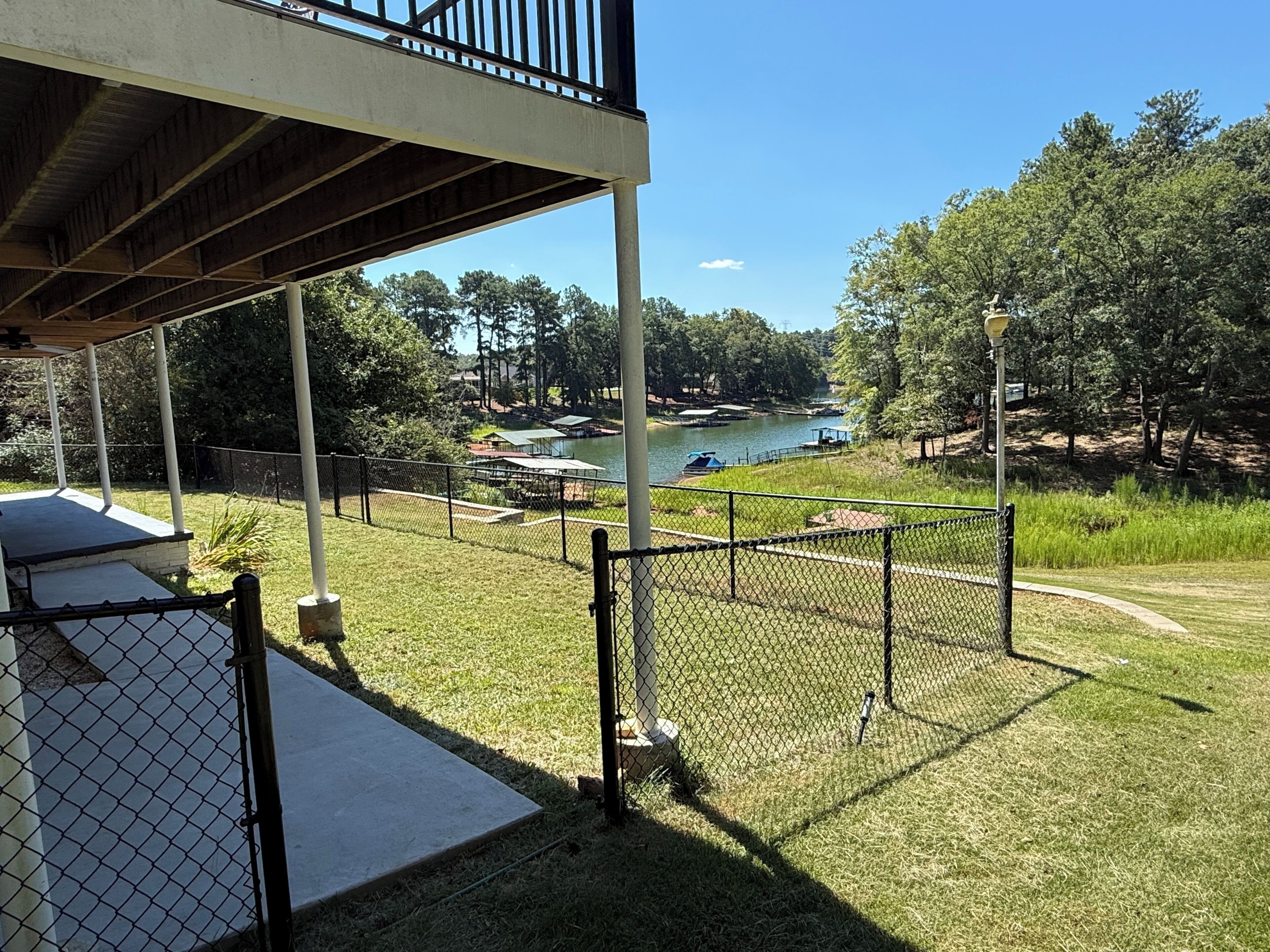 A covered outdoor area with a view of a lake and dock.