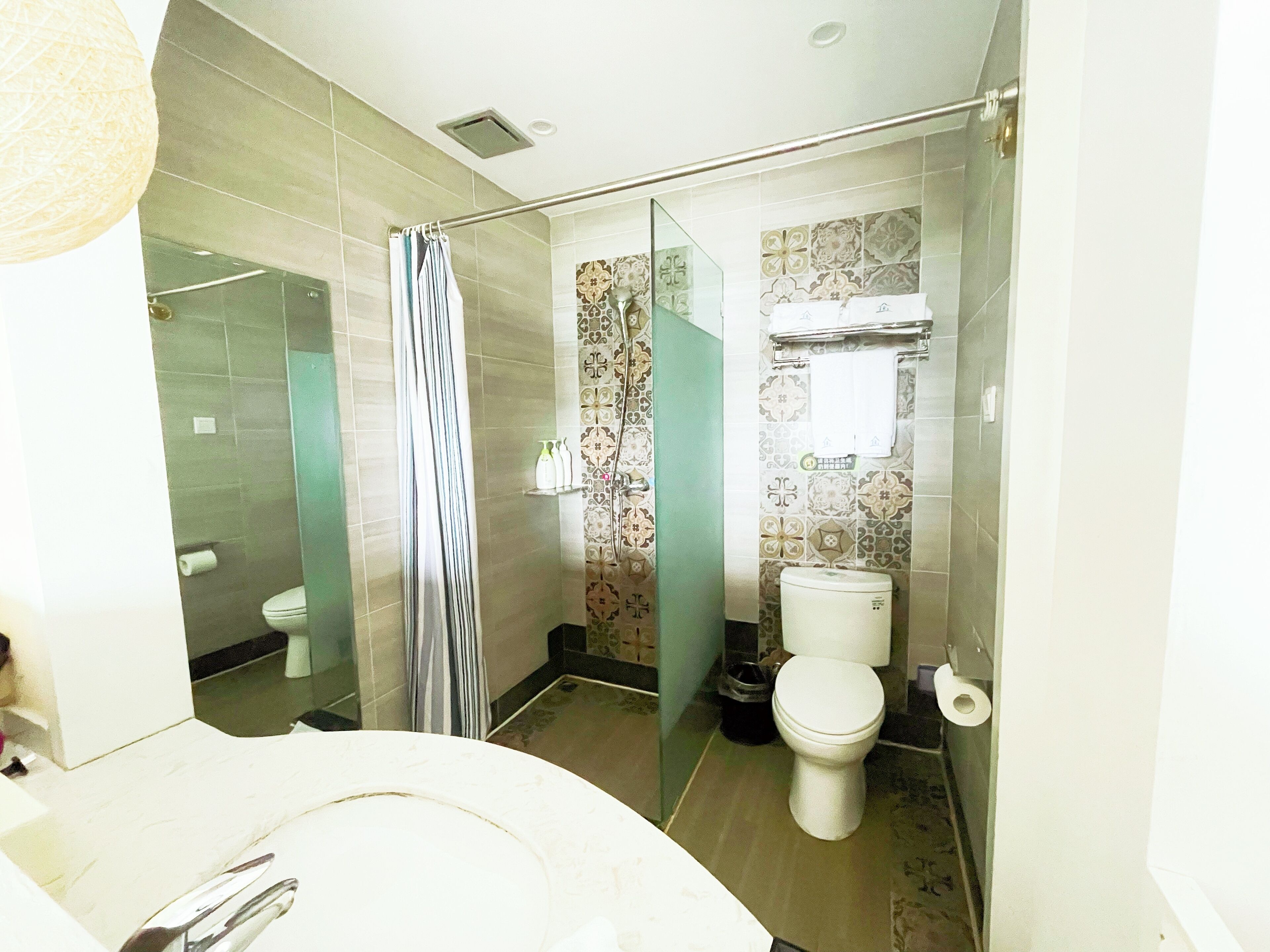A bathroom with a shower, toilet, and sink.