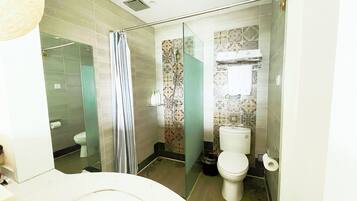 A bathroom with a shower, toilet, and sink.