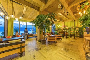 A cozy interior with wooden furniture, a large tree, and a view of the outdoors. - LS Inn Dali Liangsu Lake View (Dali)