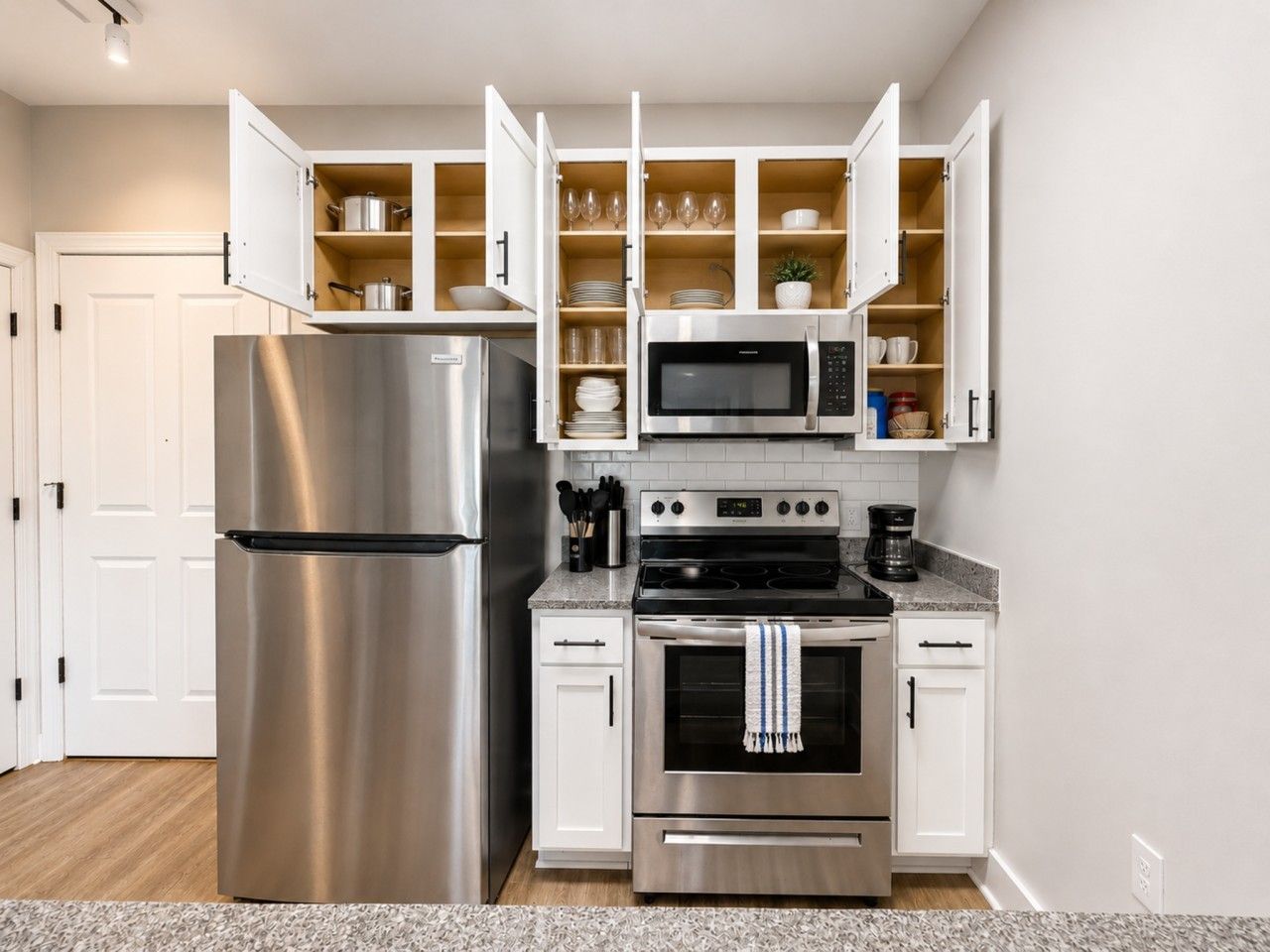 A modern kitchen with a stainless steel refrigerator, a microwave, and an oven.