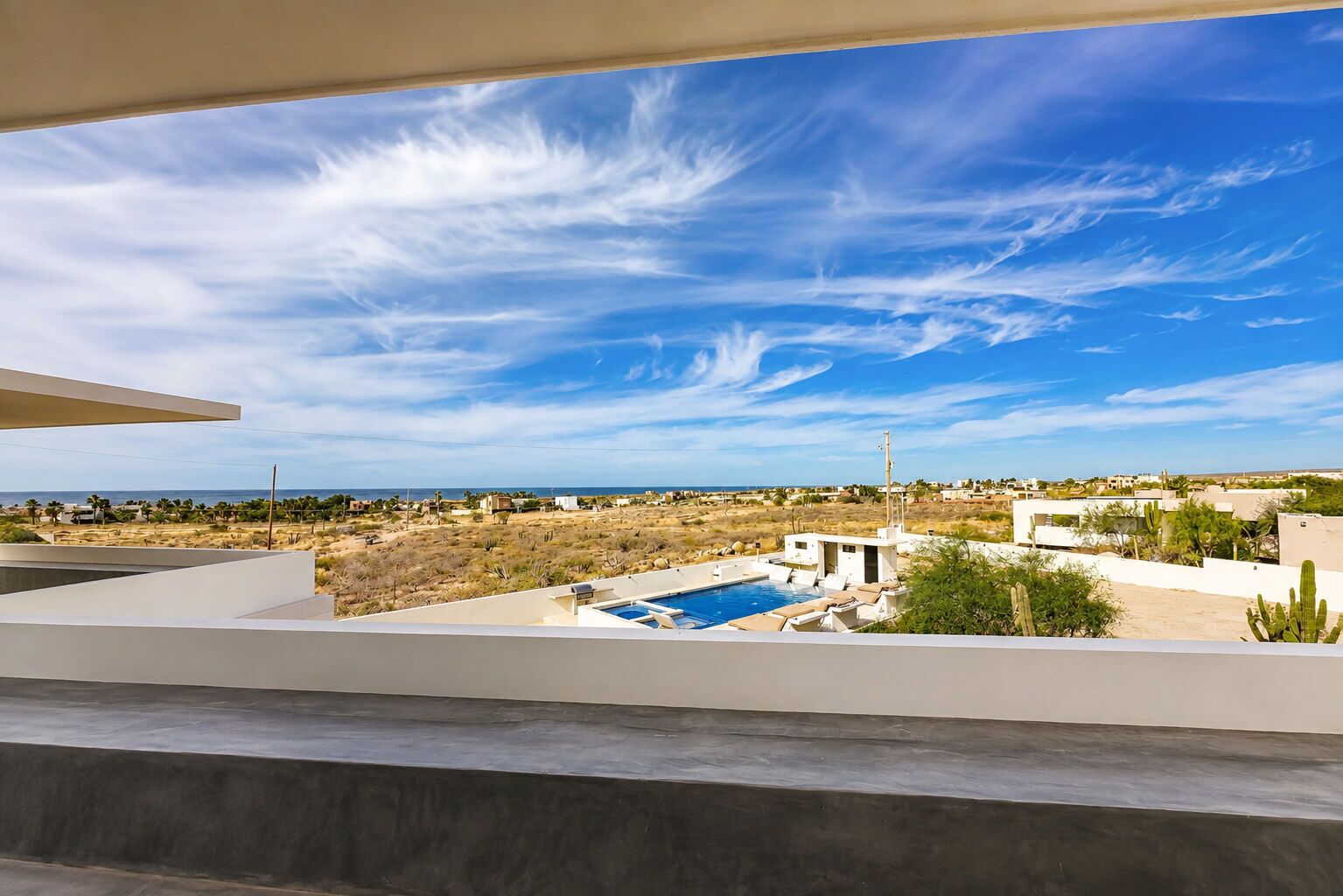 A rooftop pool with a clear view of the surrounding landscape and distant buildings.
