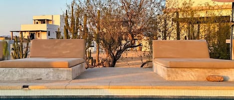 Una piscina con agua cristalina que refleja el cielo y los edificios circundantes.