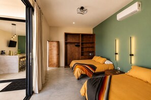 A modern hotel room with a bed, bedside tables, a wardrobe, a desk with a chair, and a television. - Dreamy desert villa: luxe pool & ocean views (Todos Santos)