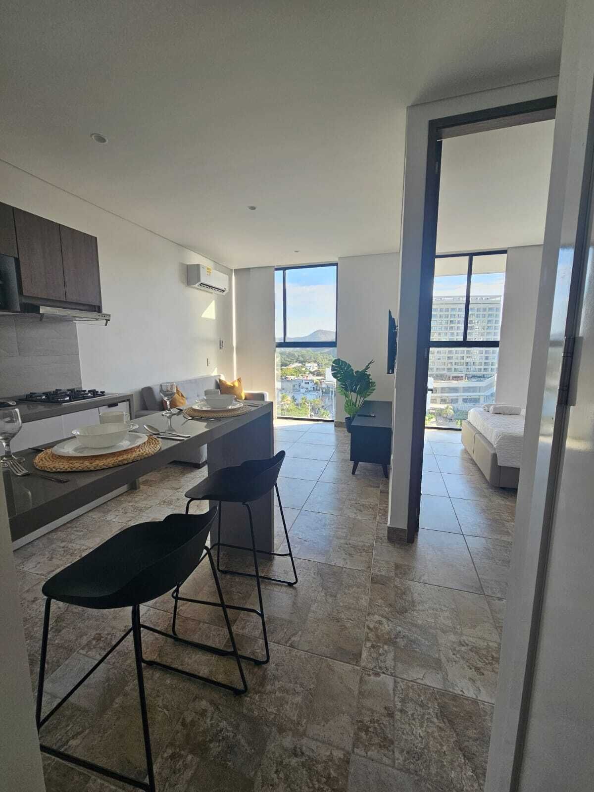 Een moderne keuken met een eetgedeelte, uitzicht op de stad en een balkon.